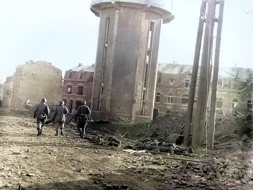 Des soldats de la 101è Division Airborne US passent à côté de leurs camarades morts durant les bombardements - Bastogne, 25 décembre 1944.