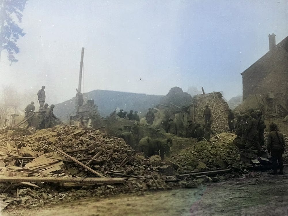 Rue de Neufchâteau à Bastogne après la destruction du dispensaire, les soldats américains fouillent les décombres, le 25 décembre 1944.